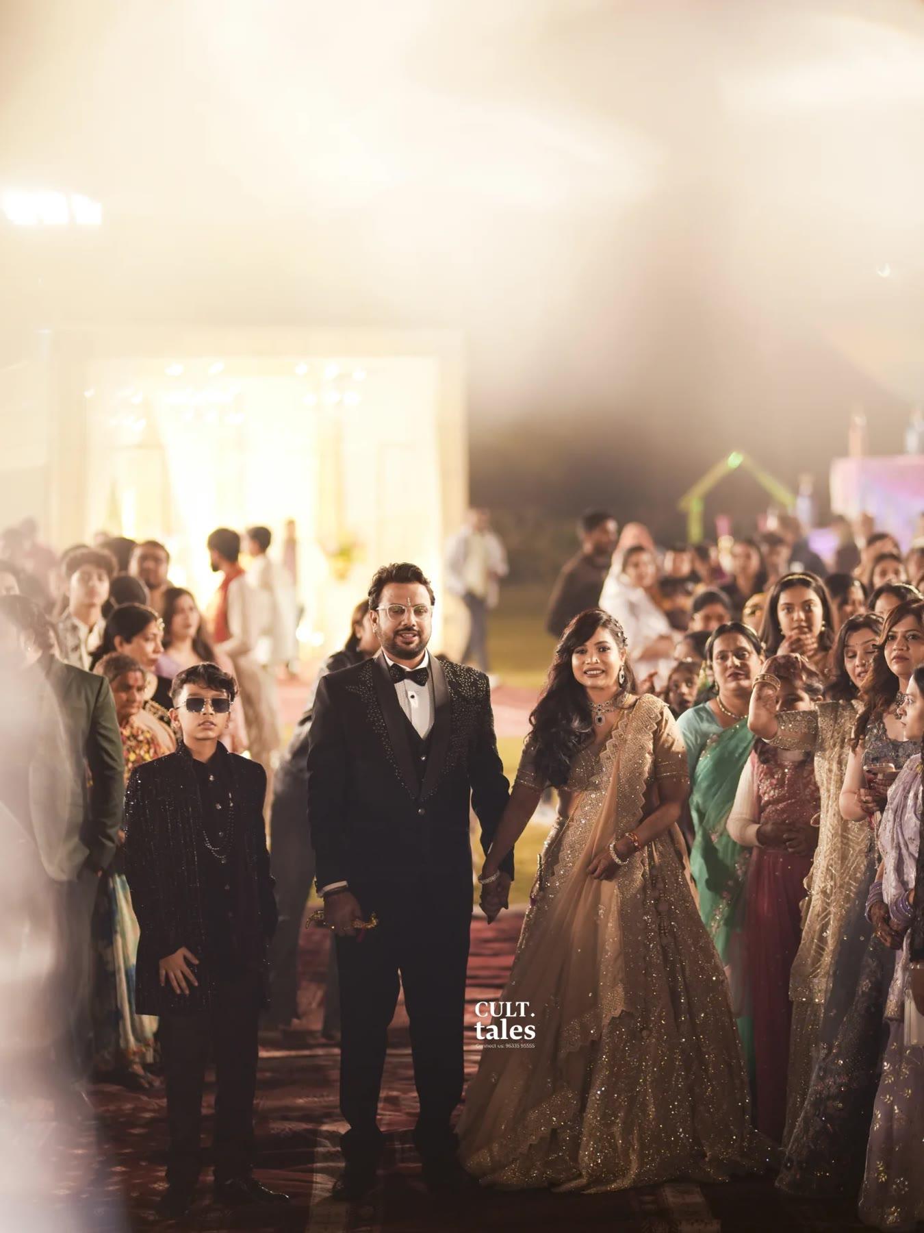 The couple walking hand in hand among their guests